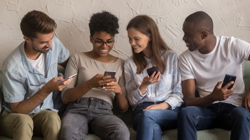 Grupo de jóvenes adultos utilizando sus teléfonos