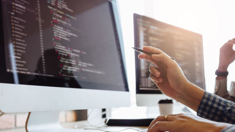 Person pointing to a computer screen with a pen