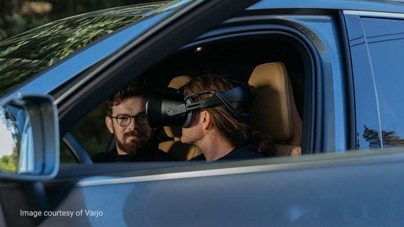 Volvo の自動車に乗って混合現実ヘッドセットを装着している女性