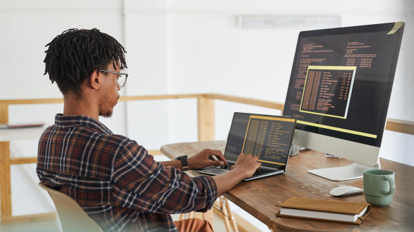 Homme rédigeant du code sur un ordinateur portable
